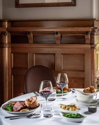 a table with plates of food and wine glasses at Norton House Hotel & Spa, Edinburgh in Ingliston