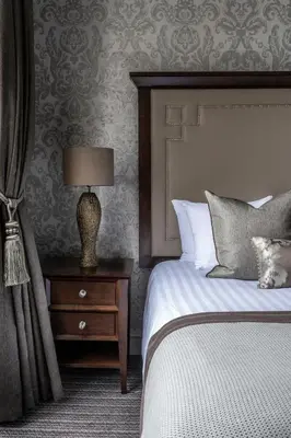 a bedroom with a bed and a lamp on a night stand at Norton House Hotel & Spa, Edinburgh in Ingliston