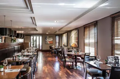 a dining room with wooden tables and chairs at Norton House Hotel & Spa, Edinburgh in Ingliston