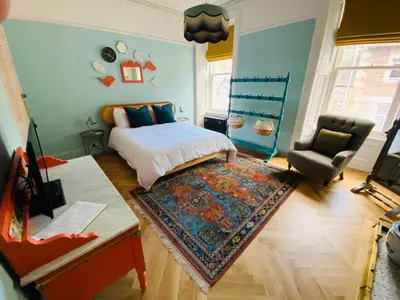 a bedroom with a bed and a chair and a rug at Ben A'an House in Callander