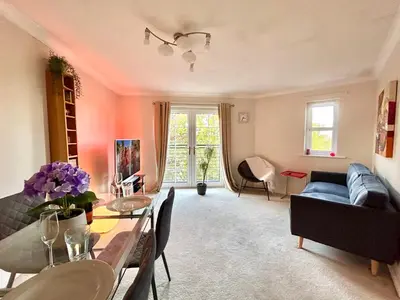 a living room with a couch and a dining room at Spekman's 3 Bedroom Ap - 20min Glasgow & Edinburgh in Falkirk