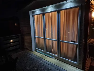a screened in porch with a window at night at Loch's Heaven 67 in Kirkcowan