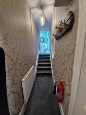 a hallway with a stairway with a fire hydrant on the wall at The Nifty Nook in Campbeltown