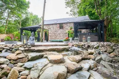a stone house with a large rock garden at The Ultimate Luss Retreat in Luss