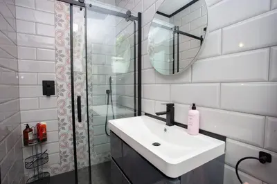 a bathroom with a sink and a shower with a mirror at The Ultimate Luss Retreat in Luss