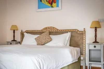 a bedroom with a large white bed with two lamps at Kilnmark Bothy in Thornhill