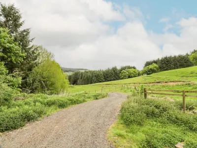 a dirt road in a field next to a fence at Kilnmark Bothy in Thornhill