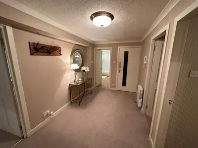 a hallway of a home with a room with a table and a lamp at One Dunbar Court Gleneagles Village in Auchterarder