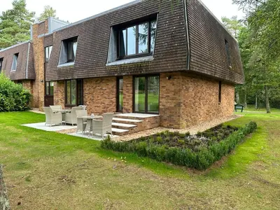a brick house with tables and chairs in a yard at One Dunbar Court Gleneagles Village in Auchterarder