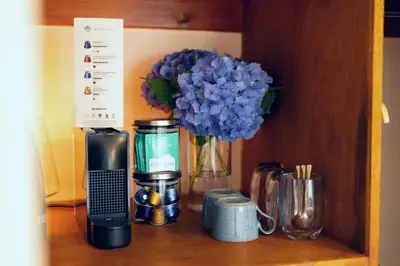 a shelf with a blender and a vase of blue flowers at Woodlands House with Hot Tub in Ballachulish