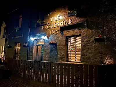 a building with a sign that reads the home exchange inn at The Horseshoe in Lochgilphead