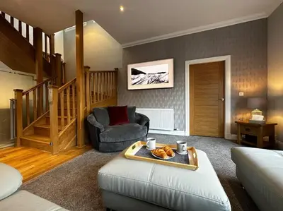 a living room with a couch and a chair at Luxury Guest House Getaway for 2 in Drymen