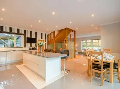 a kitchen and living room with a table and a dining room at Luxury Guest House Getaway for 2 in Drymen