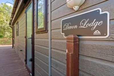 a sign for a queen lodge on the side of a building at Rivers Edge in Dollar