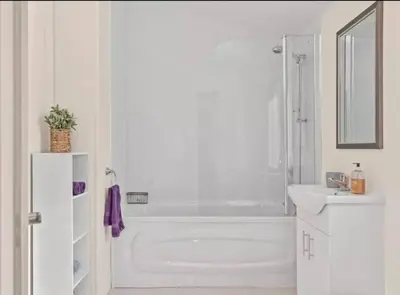 a white bathroom with a tub and a sink at Rivers Edge in Dollar