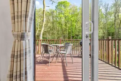 a patio with a table and chairs on a deck at Rivers Edge in Dollar
