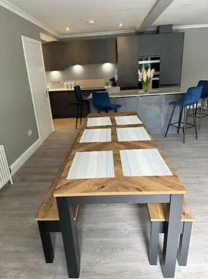 a large wooden table in a kitchen with blue chairs at Cameron Coach House Modern Property in Murrayfield Edinburgh in Edinburgh