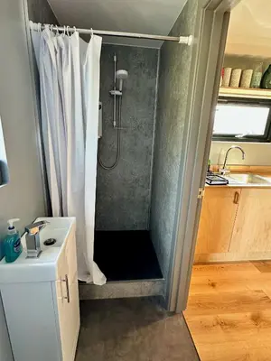 a shower with a shower curtain in a bathroom at Jura - The Black Hut in Isle of Jura