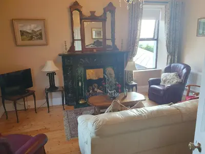 a living room with a couch and a fireplace at The Villa Farmhouse in Cushendun