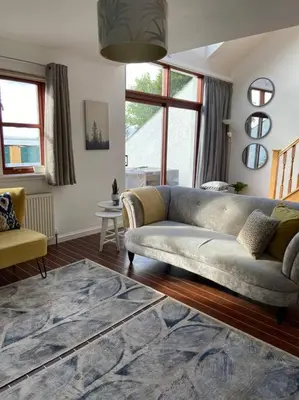a living room with a couch and a rug at Lanfine View 1 at Loudoun Mains with Hot Tub in Newmilns