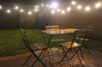 a picnic table and chairs in a backyard at night at Peaceful house in the heart of Glasgow city, close to Queen Elizabeth Hospital and Govan subway, Free Private Parking in Glasgow