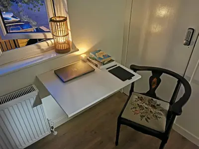 a desk with a lamp and a chair next to a window at Peaceful house in the heart of Glasgow city, close to Queen Elizabeth Hospital and Govan subway, Free Private Parking in Glasgow
