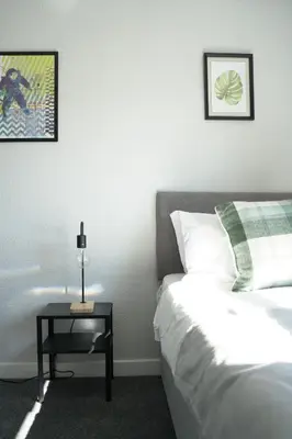 a bedroom with a bed and a table with a lamp at McCracken House in Uddingston