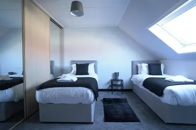 a attic bedroom with two beds and a window at Sauchie House in Sauchie