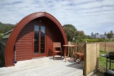 a dome tent with a table and chairs on a deck at Clovullin Croftview Pod in Ardgour