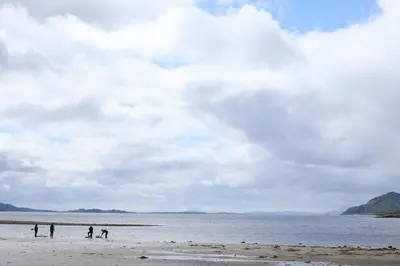 a group of people standing on the beach at Clovullin Croftview Pod in Ardgour
