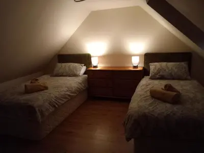 a attic bedroom with two beds and two lamps at The WEE HOUSE Balvicar Isle of Seil in Balvicar