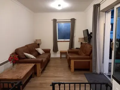 a living room with two couches and a coffee table at The WEE HOUSE Balvicar Isle of Seil in Balvicar