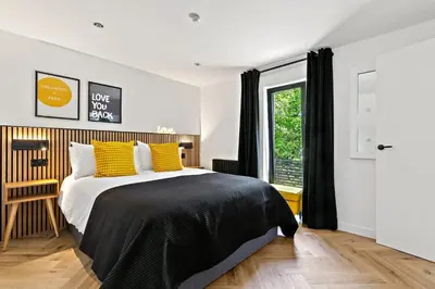 a bedroom with a bed with yellow pillows and a window at Peterswell Holiday Cottage in Houston