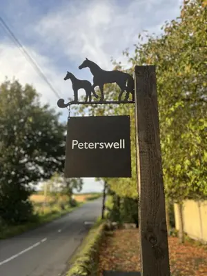 a sign with two horses on the side of a road at Peterswell Holiday Cottage in Houston
