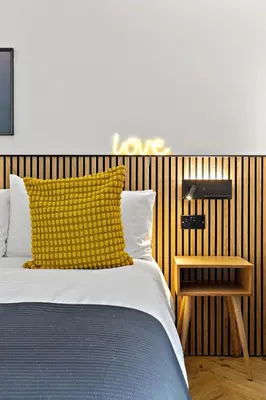 a bed with a yellow pillow and a side table at Peterswell Holiday Cottage in Houston