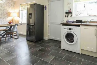 a kitchen with a washing machine in a kitchen at Beautiful cosy 2-bedroom entire house in Connel, near Oban in Connel