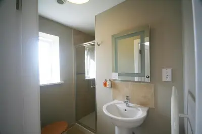 a bathroom with a sink and a shower and a toilet at The Arran Lodge & Arran Sleep Huts in Lamlash