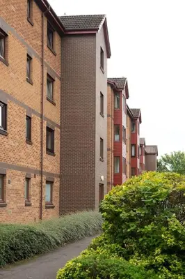 a row of brick buildings next to a street at Executive Apartment By Inverkeithing Train Station in Fife