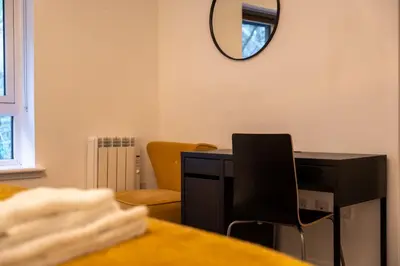 a desk with a chair and a mirror on the wall at Dalwhinnie Apartment in Oban
