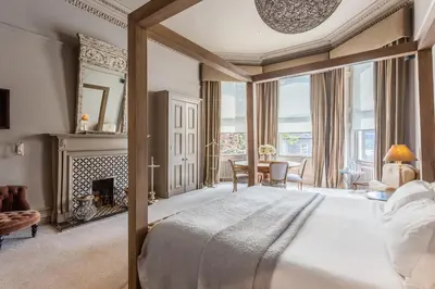 a bedroom with a large bed and a fireplace at Murrayfield Hotel in Edinburgh