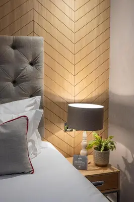 a bedroom with a bed and a lamp on a nightstand at Murrayfield Hotel in Edinburgh