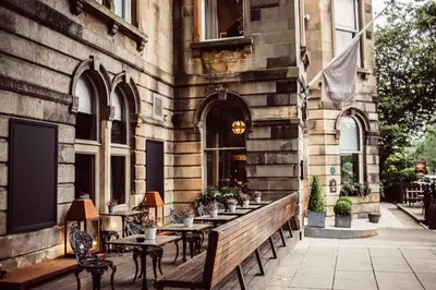 a patio with tables and chairs in front of a building at Murrayfield Hotel in Edinburgh