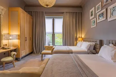 a hotel room with two beds and a desk at Murrayfield Hotel in Edinburgh