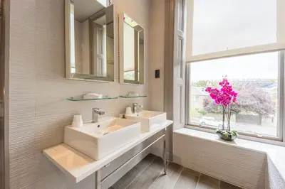 a bathroom with two sinks and a window at Murrayfield Hotel in Edinburgh