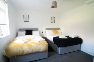 two beds sitting next to each other in a bedroom at 2 BDR Apt By Caledonia Luxe Stays Short Lets & Serviced Accommodation Airdrie in Airdrie
