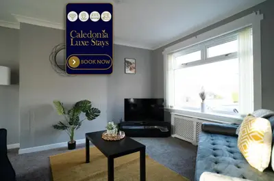 a living room with a blue couch and a table at Darmeid House in Hartwood