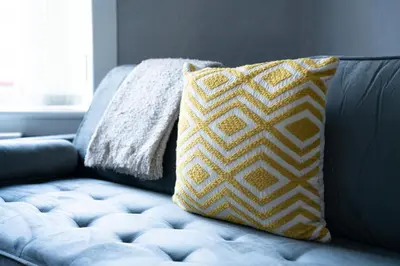 a couch with a yellow and white pillow on it at Darmeid House in Hartwood