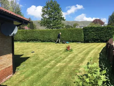 a man walking through a yard at Dingieshowe Cottage in Lennoxtown