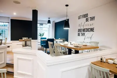 a restaurant with tables and chairs and a blackboard at Argyll Hotel in Glasgow