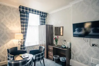 a room with a table and chairs and a window at Argyll Hotel in Glasgow
